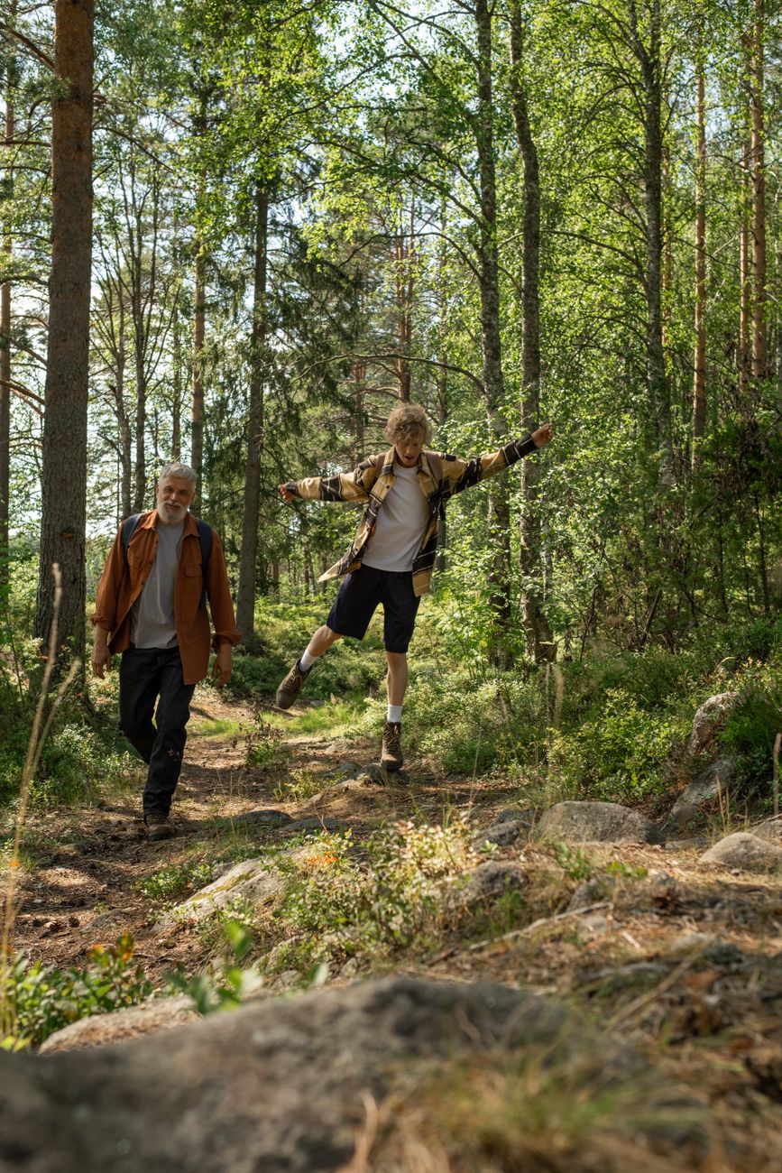 grandfather and grandson walking in the forest